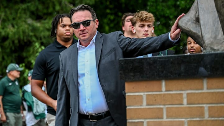 Michigan State's head coach Jonathan Smith touches the foot of the Sparty statue before the game against Florida Atlantic on Friday, Aug. 30, 2024, outside Spartan Stadium in East Lansing.