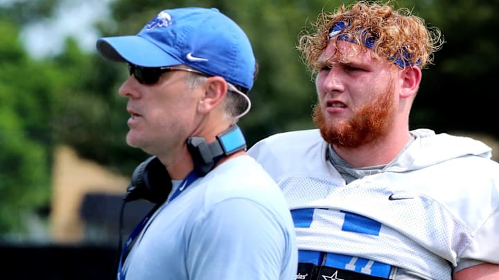 Middle Tennessee offensive coordinator Mitch Stewart watches the players practice as MTSU's offensive lineman Keylan Rutledge (77) stands behind him during a practice in 2023.