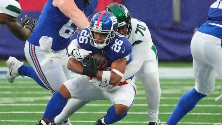 Oct 29, 2023; East Rutherford, New Jersey, USA; New York Jets defensive tackle Quinton Jefferson (70) stops New York Giants running back Saquon Barkley (26) in the first half at MetLife Stadium. 