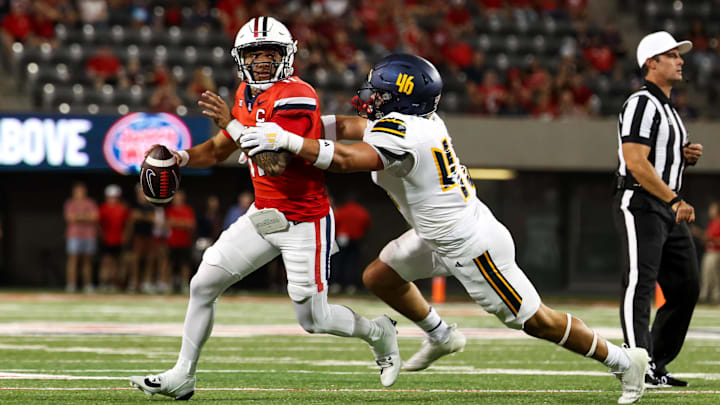 Sep 7, 2024; Tucson, Arizona, USA; Arizona Wildcats quarterback Noah Fifita (11) rolls out to pass against Northern Arizona Lumberjacks linebacker Tommy Ellis (46) during first quarter at Arizona Stadium. Sep 7, 2024; Tucson, Arizona, USA; Arizona Wildcats quarterback Noah Fifita (11) rolls out to pass against Northern Arizona Lumberjacks linebacker Tommy Ellis (46) during first quarter at Arizona Stadium.