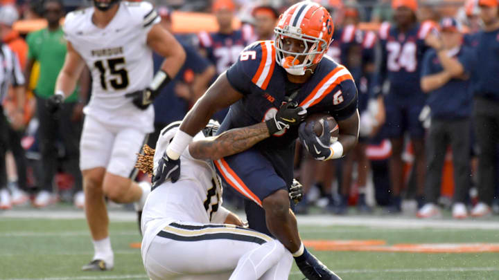 Oct 12, 2024; Champaign, Illinois, USA; Purdue Boilermakers defensive back Antonio Stevens (11) brings down Illinois Fighting Illini running back Josh McCray (6) in the first half at Memorial Stadium. Mandatory Credit: Ron Johnson-Imagn Images