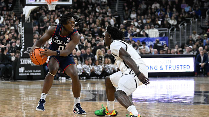 Mar 1, 2025; Providence, Rhode Island, USA; Connecticut Huskies guard Ahmad Nowell (0) passes the ball around Providence Friars guard Bensley Joseph (7) during the first half at Amica Mutual Pavilion. Mandatory Credit: Eric Canha-Imagn Images