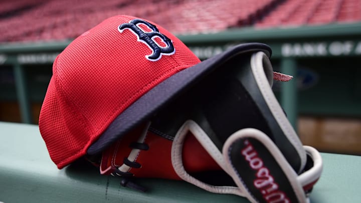 May 18, 2025; Boston, Massachusetts, USA;  A Boston Red Sox hat and glove rests on the railing by the dugout prior to a game against the Atlanta Braves at Fenway Park. Mandatory Credit: Bob DeChiara-Imagn Images