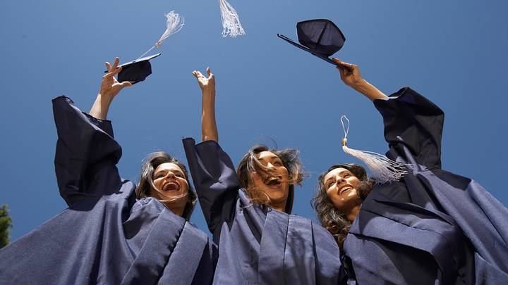 Three female graduate students throwing mortar boards Three female graduate students throwing mortar boards