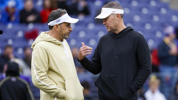 Nov 2, 2024; Seattle, Washington, USA; Washington Huskies head coach Jedd Fisch, left, talks with USC Trojans head coach Lincoln Riley during pregame warmups at Alaska Airlines Field at Husky Stadium. Mandatory Credit: Joe Nicholson-Imagn Images