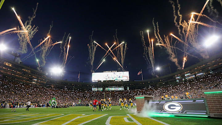 Fireworks are fired off as the Green Bay Packers run out of the tunnel before a game.
