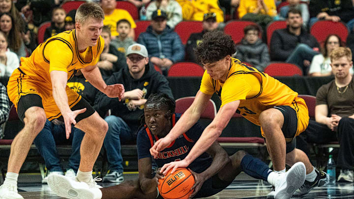 Iowa's Isaia Howard (23) grabs for a ball from Bucknell's Ruot Bijiek