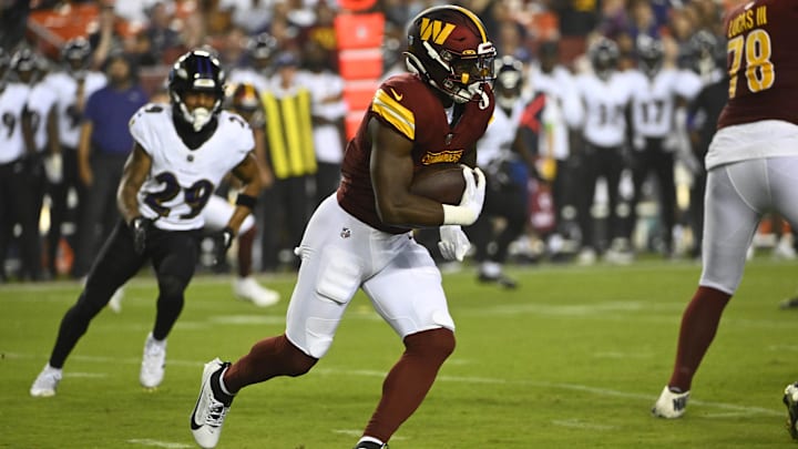 Washington Commanders running back Brian Robinson Jr. (8) carries the ball against the Baltimore Ravens during the first half at FedExField. 