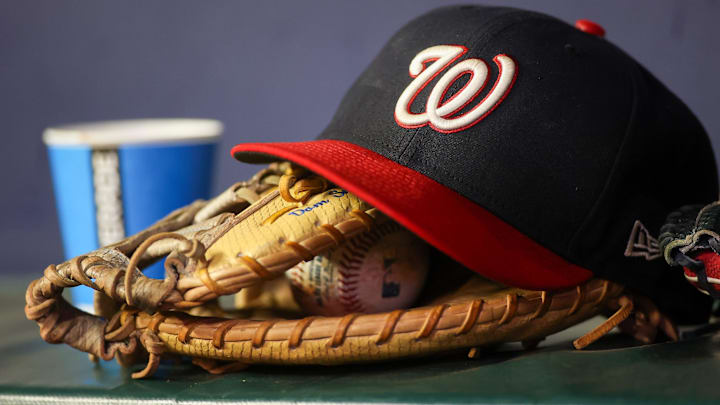 Dark blue Washington Nationals hat on top of a light brown mitt