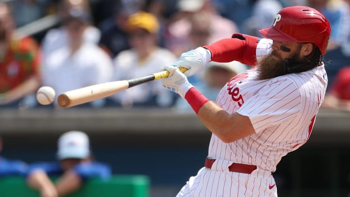 Mar 8, 2025; Clearwater, Florida, USA; Philadelphia Phillies outfielder Brandon Marsh (16) hits into a fielder’s choice reaching first base against the Toronto Blue Jays in the second inning during spring training at BayCare Ballpark. 