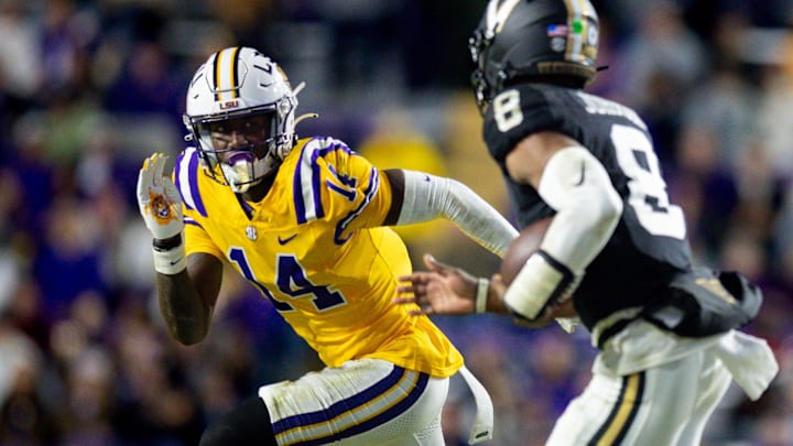 Nov 23, 2024; Baton Rouge, Louisiana, USA; LSU Tigers cornerback Zy Alexander (14) tackles Vanderbilt Commodores quarterback Nate Johnson (8) during the second half at Tiger Stadium. Mandatory Credit: Stephen Lew-Imagn Images Nov 23, 2024; Baton Rouge, Louisiana, USA; LSU Tigers cornerback Zy Alexander (14) tackles Vanderbilt Commodores quarterback Nate Johnson (8) during the second half at Tiger Stadium. Mandatory Credit: Stephen Lew-Imagn Images
