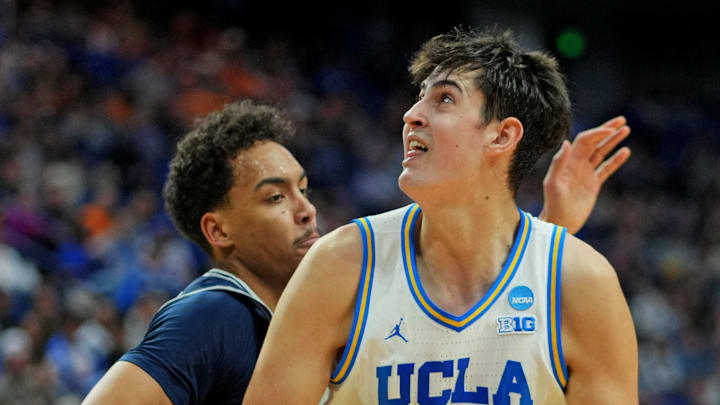 Mar 20, 2025; Lexington, KY, USA;  UCLA Bruins center Aday Mara (15) drives to the basket against Utah State Aggies guard Ian Martinez (4) during the second half in the first round of the NCAA Tournament at Rupp Arena. Mandatory Credit: Aaron Doster-Imagn Images