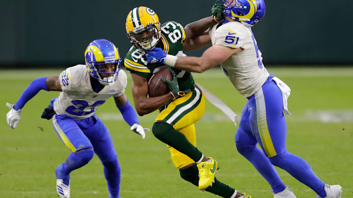 Green Bay Packers wide receiver Marquez Valdes-Scantling (83) runs for a first down on reception against Los Angeles Rams cornerback Troy Hill (22) and inside linebacker Troy Reeder (51) during their NFL divisional playoff game Saturday, January 16, 2021, at Lambeau Field in Green Bay, Wis.