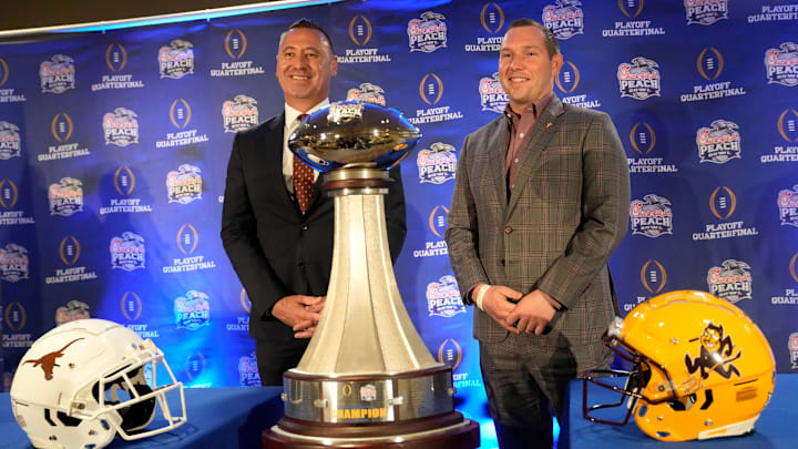 Texas head coach Steve Sarkisian and Arizona State head coach Kenny Dillingham pose for photos before facing off in the Chick-fil-A Peach Bowl.