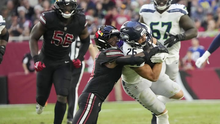 Seattle Seahawks running back Zach Charbonnet (26) is tackled by Arizona Cardinals safety Budda Baker (3) during the fourth quarter at State Farm Stadium in Glendale on Dec. 8, 2024.