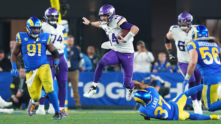 Jan 13, 2025; Glendale, AZ, USA; Minnesota Vikings quarterback Sam Darnold (14) runs the ball against the Los Angeles Rams during the second half in an NFC wild card game at State Farm Stadium. Mandatory Credit: Joe Camporeale-Imagn Images