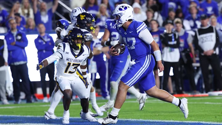 Oct 3, 2025; Provo, Utah, USA; Brigham Young Cougars quarterback Bear Bachmeier (47) runs for a touchdown against West Virginia Mountaineers safety Derek Carter Jr. (13) during the second quarter at LaVell Edwards Stadium. Mandatory Credit: Rob Gray-Imagn Images