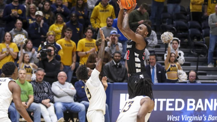 Jan 6, 2026; Morgantown, West Virginia, USA; Cincinnati Bearcats forward Jalen Celestine (32) shoots a three pointer over West Virginia Mountaineers guard Honor Huff (3) during the second half at Hope Coliseum. Mandatory Credit: Ben Queen-Imagn Images