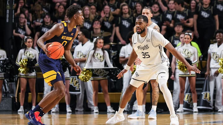Feb 14, 2026; Orlando, Florida, USA; UCF Knights forward Devan Cambridge (35) defends West Virginia Mountaineers forward Brenen Lorient (0) during the second half at Addition Financial Arena. Mandatory Credit: Mike Watters-Imagn Images
