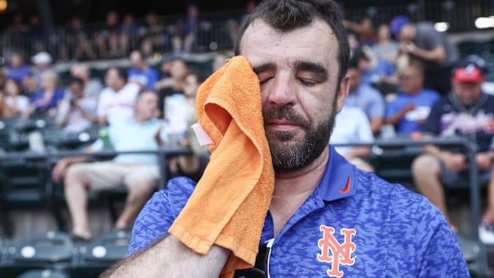 Jun 23, 2025; New York City, New York, USA;  A fan attempts to cool off during the game between the Atlanta Braves and the New York Mets at Citi Field. Mandatory Credit: Wendell Cruz-Imagn Images