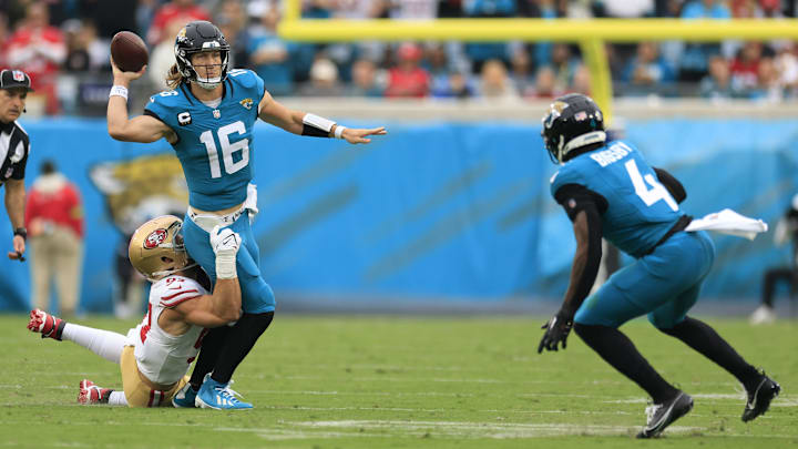 San Francisco 49ers defensive end Nick Bosa (97) hangs on to Jacksonville Jaguars quarterback Trevor Lawrence (16) as he passes the ball to Jacksonville Jaguars running back Tank Bigsby (4) who tipped the pass for an interception during the third quarter of an NFL football game Sunday, Nov. 12, 2023 at EverBank Stadium in Jacksonville, Fla. The San Francisco 49ers defeated the Jacksonville Jaguars 34-3. [Corey Perrine/Florida Times-Union]