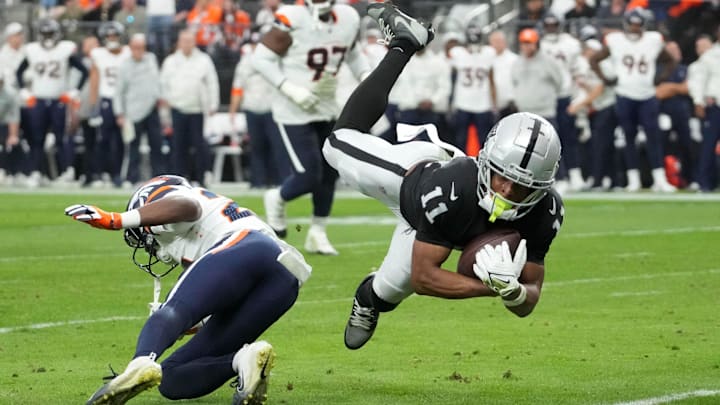 Nov 24, 2024; Paradise, Nevada, USA; Las Vegas Raiders wide receiver Tre Tucker (11) carries the ball against Denver Broncos cornerback Ja'Quan McMillian (29) in the second quarter  at Allegiant Stadium. Mandatory Credit: Kirby Lee-Imagn Images