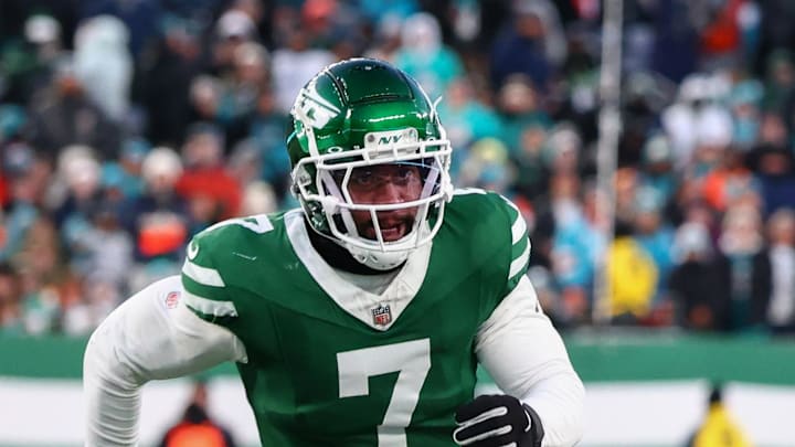 Miami Dolphins quarterback Tyler Huntley runs with the ball while being pursued by New York Jets defensive end Haason Reddick.