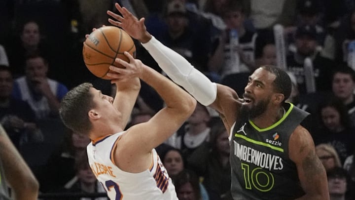 Mar 28, 2025; Minneapolis, Minnesota, USA; Phoenix Suns guard Collin Gillespie (12) shoots against Minnesota Timberwolves guard Mike Conley (10) in the first quarter at Target Center. Mandatory Credit: Bruce Kluckhohn-Imagn Images
