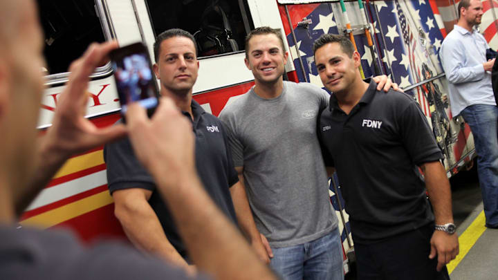 69623 New York 9/10/2010 METS WITH NYFD: Fire fighters Frank Sansonetti, left, and Sal Cotrona (cq), right pose for photos with David Wright of the Mets  during his visit to Ladder 10, Engine 10 (or the 10 house) in lower Manhattan Friday afternoon.