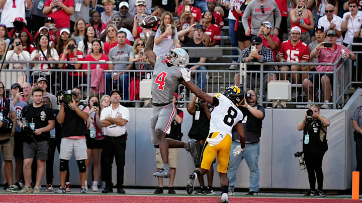 Oct 5, 2024; Columbus, OH, USA; Ohio State Buckeyes wide receiver Jeremiah Smith (4) makes a touchdown grab against Iowa Hawkeyes defensive back Deshaun Lee (8) in the third quarter during the NCAA football game at Ohio Stadium.