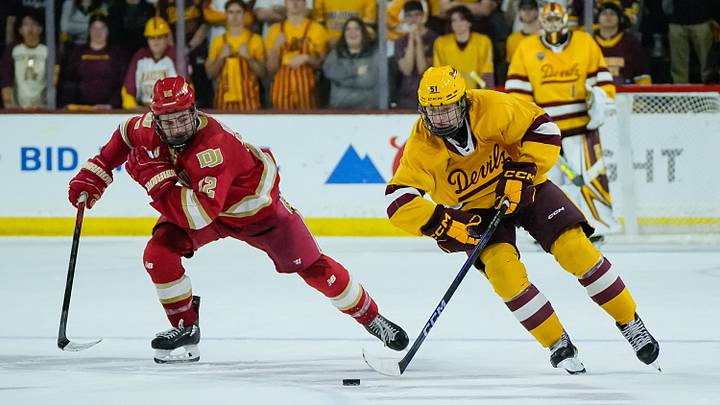 Sam Harris (12) of the Denver Pioneers follows Cruz Lucius (51) of the Arizona State Sun Devils down the ice as they play 3-on-3 in overtime at Mullett Arena on Feb. 8, 2025, in Tempe, Ariz.