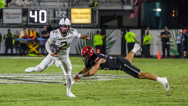 Aug 28, 2025; Orlando, Florida, USA; UCF Knights quarterback Tayven Jackson (2) avoids a tackle during the second quarter against the Jacksonville State Gamecocks at Acrisure Bounce House. Mandatory Credit: Mike Watters-Imagn Images