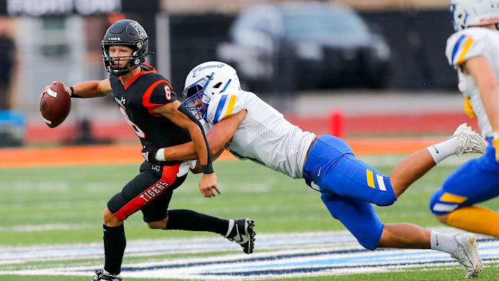 Norman   s Phoenix Murphy (6) is sacked by Stillwater   s Nehemiah Kolone (7) during a high school football game between Stillwater High School and Norman High School in Norman, Okla., on Thursday, Sept. 14, 2023.