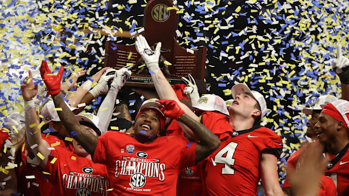Dec 7, 2024; Atlanta, GA, USA; The Georgia Bulldogs celebrate with the trophy after defeating the Texas Longhorns in overtime in the 2024 SEC Championship game at Mercedes-Benz Stadium. Mandatory Credit: Brett Davis-Imagn Images
