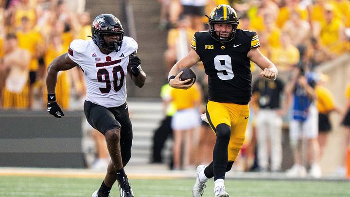 Iowa Hawkeyes quarterback Hank Brown (9) runs toward the Iowa sideline as Northern Illinois’ Kole Sneed (90) pursues him on Sept. 5, 2026, at Kinnick Stadium in Iowa City.