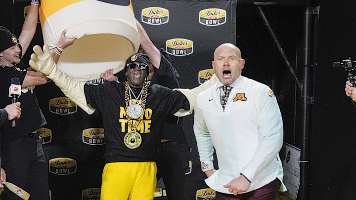 Jan 3, 2025; Charlotte, NC, USA; Flavor Flav surprises Minnesota Golden Gophers head coach P.J. Fleck and his team after their win over Virginia Tech Hokies at the Duke’s Mayo Bowl at Bank of America Stadium. Mandatory Credit: Jim Dedmon-Imagn Images Jan 3, 2025; Charlotte, NC, USA; Flavor Flav surprises Minnesota Golden Gophers head coach P.J. Fleck and his team after their win over Virginia Tech Hokies at the Duke’s Mayo Bowl at Bank of America Stadium. Mandatory Credit: Jim Dedmon-Imagn Images