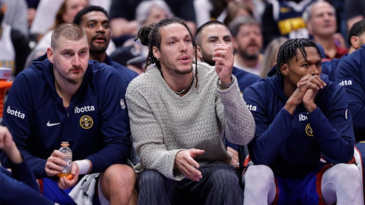 Nov 28, 2025; Denver, Colorado, USA; Denver Nuggets forward Aaron Gordon (C) looks on from the bench with center Nikola Jokic (15) and guard Peyton Watson (8) in the fourth quarter against the San Antonio Spurs at Ball Arena.