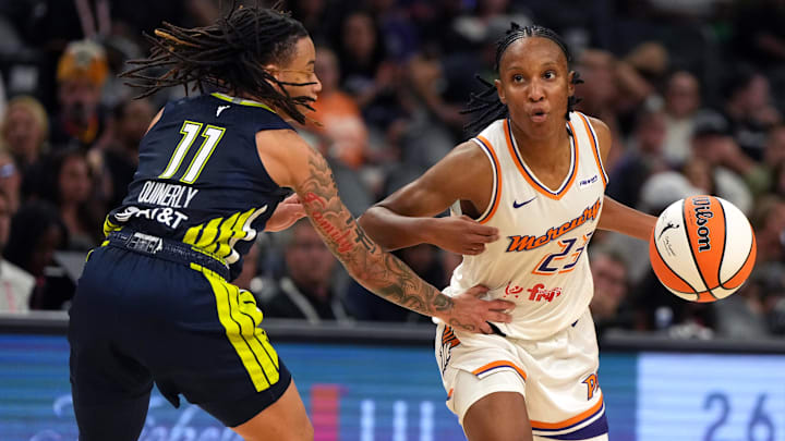Jul 7, 2025; Phoenix, Arizona, USA; Phoenix Mercury guard Kiana Williams drives on Dallas Wings guard JJ Quinerly (11) in the second half at Footprint Center. Mandatory Credit: Rick Scuteri-Imagn Images