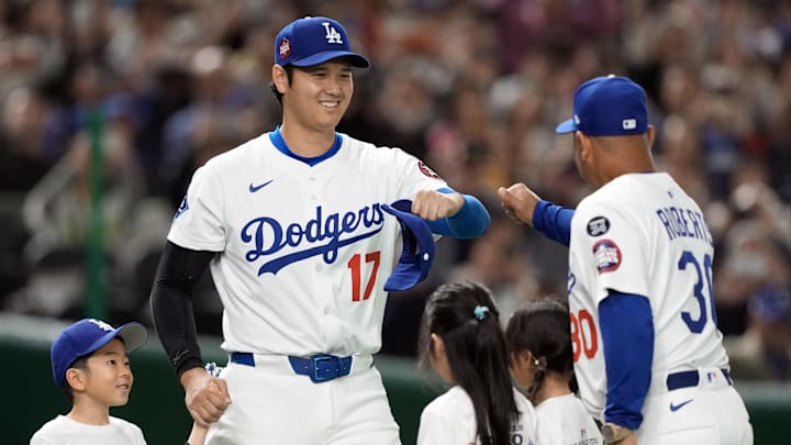 Mar 16, 2025; Bunkyo, Tokyo, Japan; Los Angeles Dodgers designated hitter Shohei Ohtani (17) greets manager Dave Roberts (30) during player introductions before the game against the Hanshin Tigers at Tokyo Dome. Mandatory Credit: Darren Yamashita-Imagn Images
