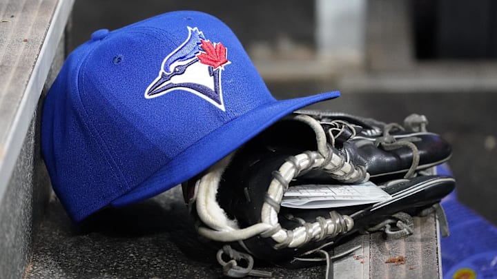Apr 16, 2025; Toronto, Ontario, CAN; A Toronto Blue Jays hat and glove in the dugout during a game against the Atlanta Braves at Rogers Centre. Mandatory Credit: John E. Sokolowski-Imagn Images