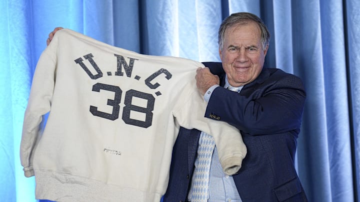 Dec 12, 2024; Chapel Hill, NC, USA;   North Carolina Tar Heels new head coach Bill Belichick holds up the sweatshirt worn by his father when he was an assistant coach at New North Carolina Tar Heels new at Loudermilk Center for Excellence. Mandatory Credit: Jim Dedmon-Imagn Images