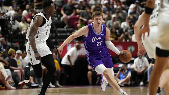 Jul 14, 2025; Las Vegas, NV, USA;  Utah Jazz forward Kyle Filipowski (22) dribbles the ball against San Antonio Spurs forward Osayi Osifo (26) during the first half of a NBA basketball game at Thomas & Mack Center. Mandatory Credit: Lucas Peltier-Imagn Images