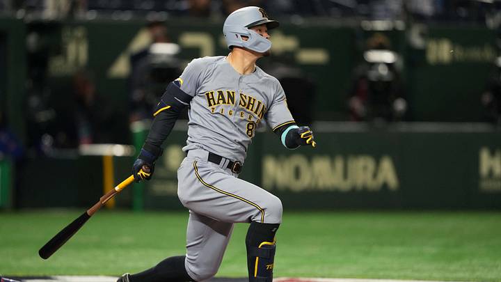Mar 15, 2025; Bunkyo, Tokyo, Japan; Hanshin Tigers right fielder Teruaki Sato (8) hits an RBI single against the Chicago Cubs during the fifth inning at Tokyo Dome. Mandatory Credit: Darren Yamashita-Imagn Images