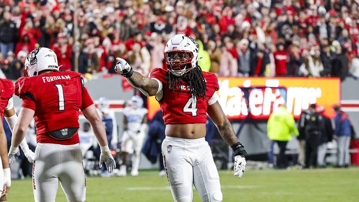 Nov 29, 2025; Raleigh, North Carolina, USA; NC State Wolfpack defensive end Tra Thomas (4) reacts to defensive end Travali Price (13) going down during the second half of the game against the North Carolina Tar Heels at Carter-Finley Stadium.  Mandatory Credit: Jaylynn Nash-Imagn Images