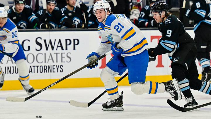 Jan 9, 2026; Salt Lake City, Utah, USA; St. Louis Blues right wing Jimmy Snuggerud (21) lines up his next shot ahead of Utah Mammoth right wing Clayton Keller (9) during third period at Delta Center. Mandatory Credit: Peter Creveling-Imagn Images