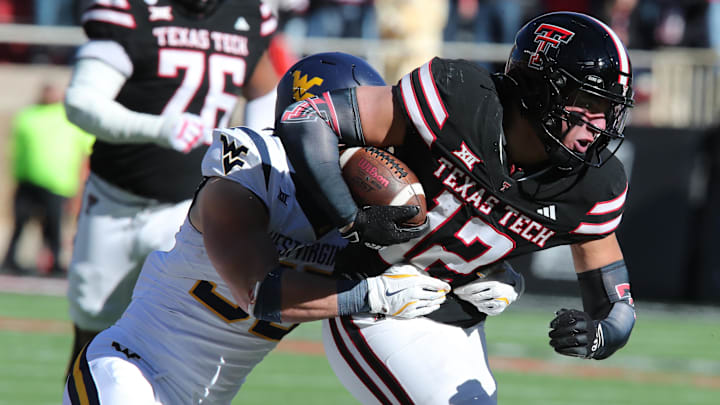 Nov 30, 2024; Lubbock, Texas, USA;  Texas Tech Red Raiders tight end Jalin Conyers (12) runs the ball against West Virginia Mountaineers defensive back Reid Carrico (35) in the first half at Jones AT&T Stadium and Cody Campbell Field. Mandatory Credit: Michael C. Johnson-Imagn Images