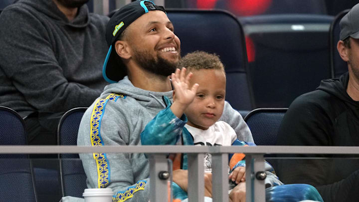 Jul 2, 2022; San Francisco, CA, USA; Golden State Warriors guard Stephen Curry (30) sits in the stands with son Canon.