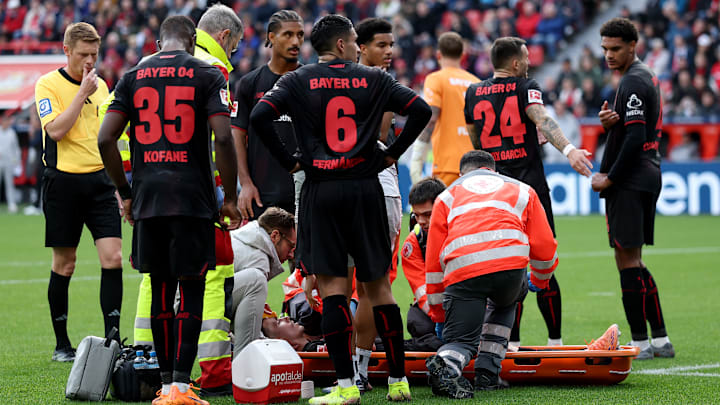 Die Profis von Bayer Leverkusen mit sorgenvoller Mine: Mitspieler Alejandro Grimaldo verletzt am Boden