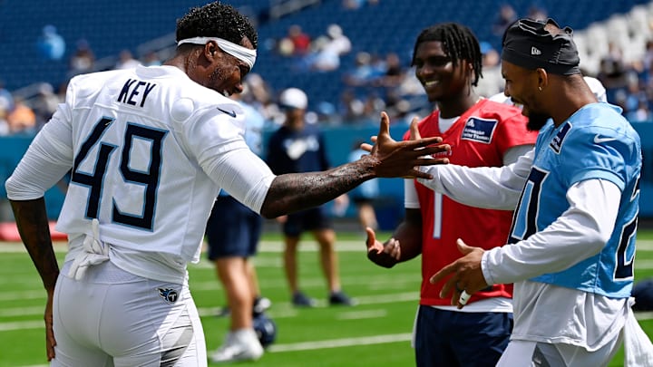 Tennessee Titans linebacker Arden Key (49) and running back Tony Pollard (20) slap hands during “Back Together Weekend” training camp practice at Nissan Stadium Saturday, July 26, 2025, in Nashville, Tenn.