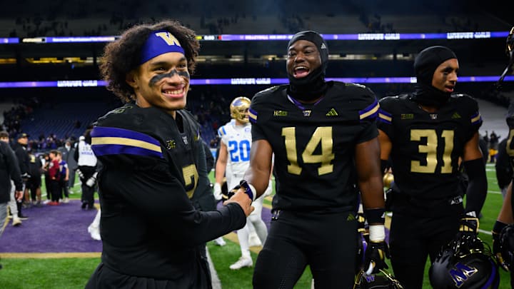 Nov 15, 2024; Seattle, Washington, USA; Washington Huskies quarterback Demond Williams Jr. (2) and edge rusher Milton Hopkins Jr. (14) celebrate after defeating the UCLA Bruins at Alaska Airlines Field at Husky Stadium. Mandatory Credit: Steven Bisig-Imagn Images